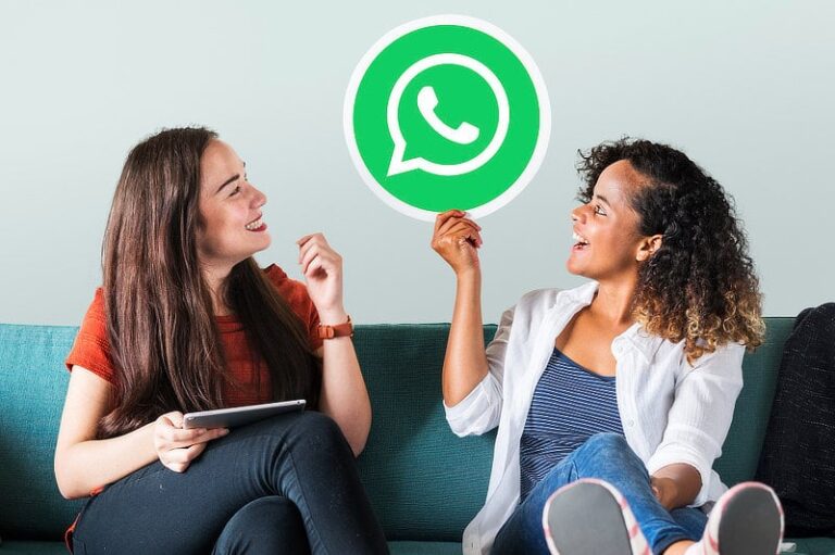 Young women showing a WhatsApp messenger icon.